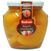 The 560g clear jar labeled "Budrum - Peeled Peach Compote" contains peeled peaches and the label indicates there are no added preservatives, colors, or sweeteners.